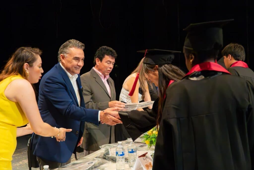 Jesús Ruiz Uribe entrega diplomas a jóvenes graduados en ceremonia de egreso en Tijuana, Baja California.