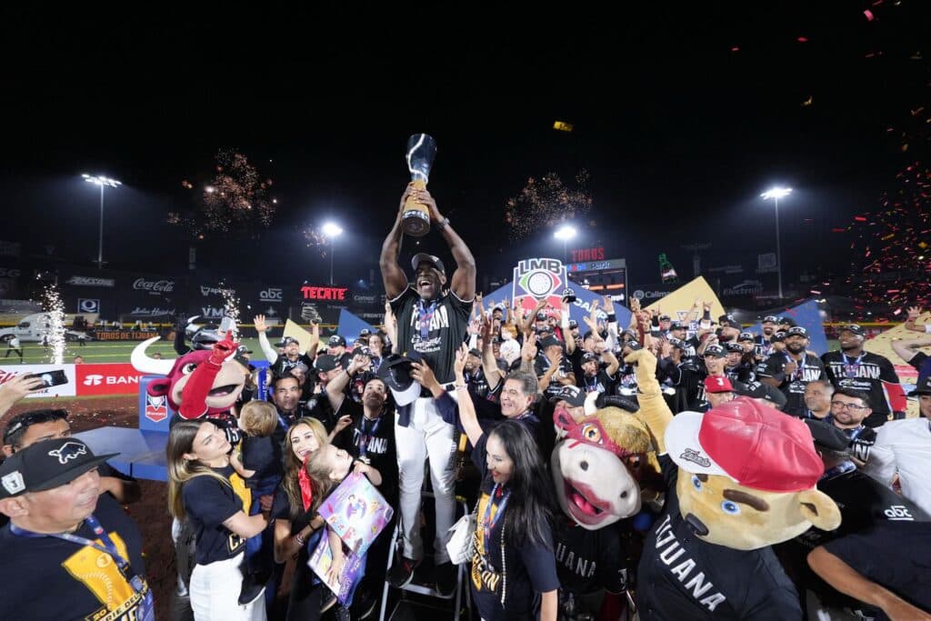 Jugadores y aficionados de los Toros de Tijuana celebran con el trofeo de campeones de la LMB en el Toros Mobil Park,
